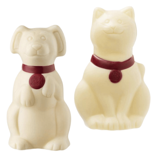Two white chocolate dog and cat figurines with red collars on a white background